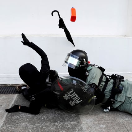 A riot police officer attempts to subdue a protester during an anti-government demonstration in Hong Kong. Photo: Reuters
