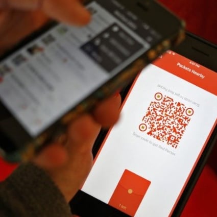 A WeChat user scans a QR code to retrieve a digital red envelope on the WeChat app on a mobile phone during the Chinese New Year period in Beijing in 2017. Photo: EPA/STR