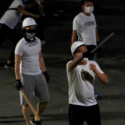 Men in white T-shirts armed with poles are seen in Yuen Long after attacking anti-extradition bill demonstrators at the MTR station in July. Photo: Reuters