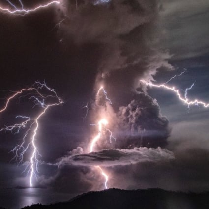 Lightning strikes as a column of ash surrounds the crater during the eruption. Photo: Handout