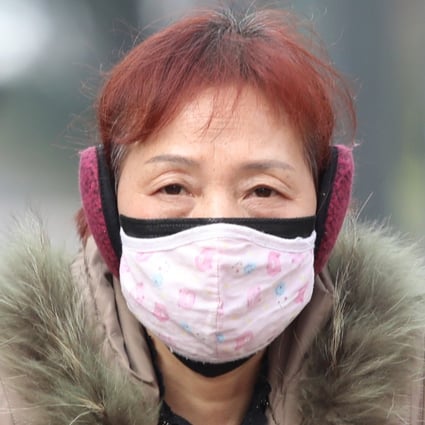 A cyclist wears a mask while riding past a bus station near the closed Huanan Seafood Wholesale Market in Wuhan on Monday. Photo: EPA-EFE