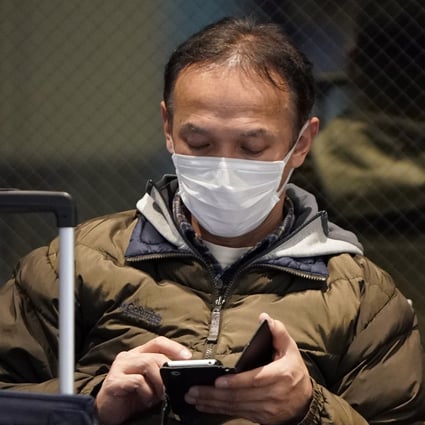 Travellers wear masks at the Tokyo International Airport on Wednesday. Photo: EPA-EFE