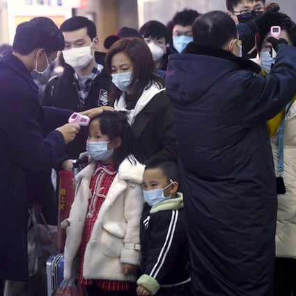 Passengers from Wuhan go through temperature checks at a train station in Hangzhou on Thursday. Authorities say younger people are not considered highly susceptible to the virus. Photo: AP