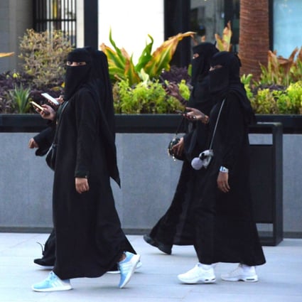 A Saudi woman wearing Western clothes walks past other women wearing conservative clothing in the capital, Riyadh. Photo: AFP