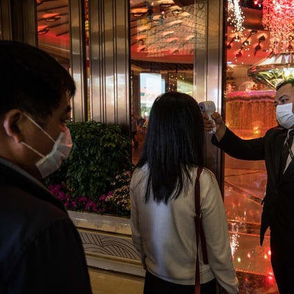 An attendant checks the temperature of a tourist at the entrance to the Galaxy Macau casino and hotel, on Friday. Tourists to the city had fallen because of the Wuhan virus outbreak. Photo: Bloomberg