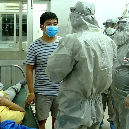 Officials from Vietnam’s Ministry of Health talk to the two men who tested positive for the coronavirus. Photo: EPA