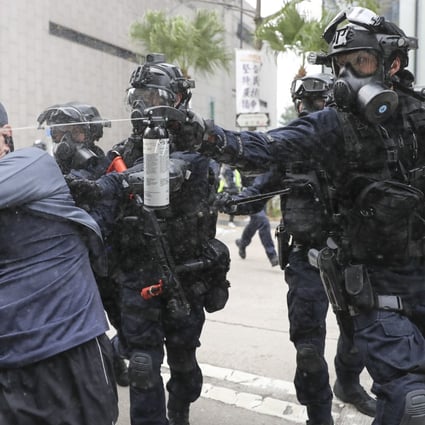A police officer fires pepper spray at an anti-government protester during a rally in Central. Photo: Sam Tsang
