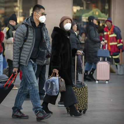 Travelers wear face masks as they walk outside of the Beijing Railway Station, Monday, Jan. 20, 2020. Photo: AP