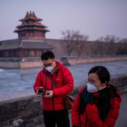 A couple walk near the deserted Forbidden City in Beijing this week. The coronavirus is rapidly spreading. Photo: AFP