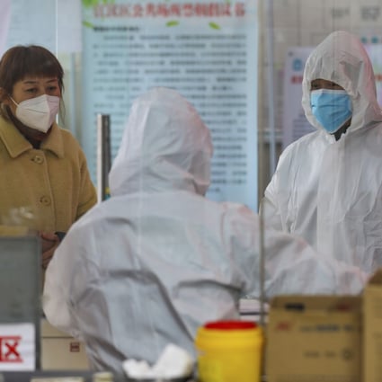 Medical workers in Wuhan assess a woman suspected of having the coronavirus on Monday as efforts to contain the disease continued. Photo: AP