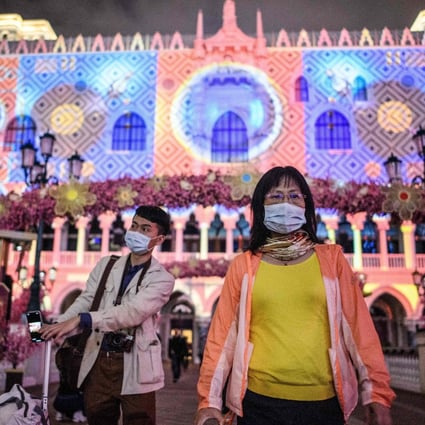 Visitors wear face masks as they walk outside the Venetian casino hotel resort in Macau, which on Januar 22 reported its first case of the novel coronavirus. Photo: AFP