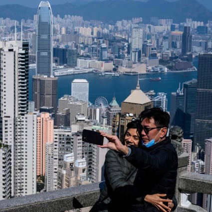 A couple take a selfie sans face masks, with Hong Kong’s famous skyline in the backdrop. Photo: AFP
