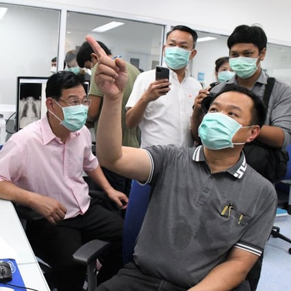 Thai Health Minister Anutin Charnvirakul, right, views closed circuit video images of coronavirus patients at Bamrasnaradura Infectious Disease Institute in Nonthaburi outside Bangkok. Photo: AFP