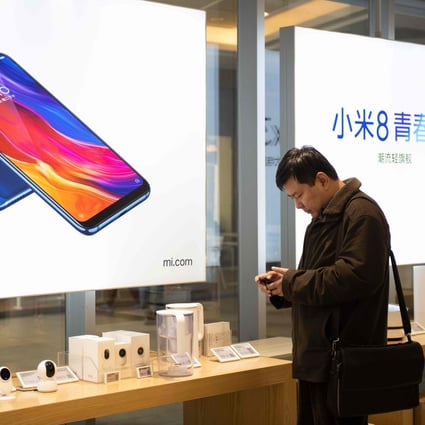 A man looks at a mobile phone in a Xiaomi shop in Beijing. File photo: AFP