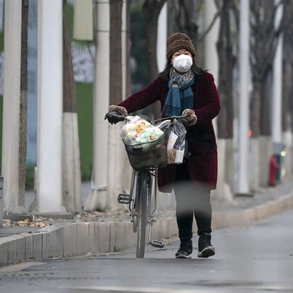 A woman in a protective mask walks along a street in Wuhan, the epicentre of the coronavirus outbreak. Photo: Xinhua