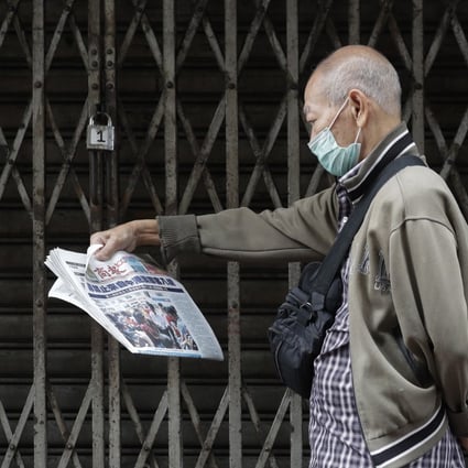 A man wearing a protective mask in Manila’s Chinatown reads a Chinese-language newspaper that says “Philippines bans travellers from China, Hong Kong and Macau”. Photo: AP