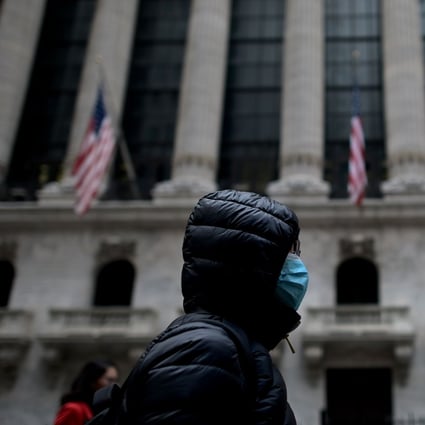A woman wearing a protective mask passes the New York Stock Exchange on Monday. The US says its offer to join a World Health Organisation mission to China to fight the coronavirus has been accepted. Photo: AFP