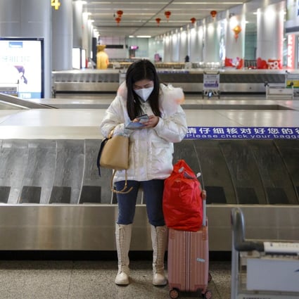 A woman checks her phone at an empty luggage collection hall at the airport in Changsha, Hunan province. The Cyberspace Administration of China has clamped down on online media platforms in a bid to maintain social stability amid the coronavirus crisis. Photo: Reuters