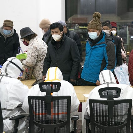 Medical workers in Wuhan help patients infected with the novel coronavirus check in at a makeshift hospital, converted from an exhibition centre, on Wednesday. Photo: Xinhua