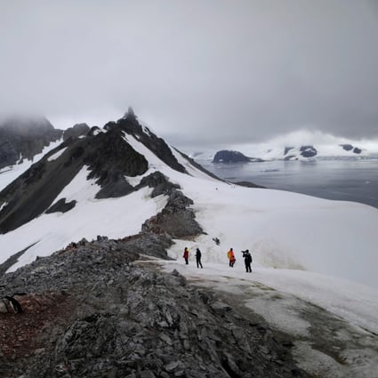 People walk along Orne Harbour, Antarctica, on February 6. The melting of Antarctic ice is causing sea levels to rise 3mm a year, a process that will only speed up as the region records higher temperatures. Photo: Reuters