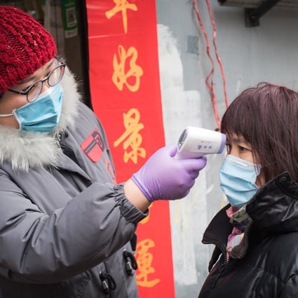 A community worker checks body temperature for a resident at a street near the Yellow Crane Pavilion in Wuhan, central China's Hubei Province, on Friday. Photo: Xinhua
