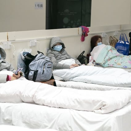 A patient uses her smartphone at a makeshift hospital converted from an exhibition centre in Wuhan, in central China’s Hubei province, on February 5, 2020. Photo: Xinhua