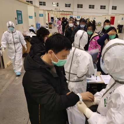 Medical workers take in patients at a cultural building converted into a treatment centre for coronavirus cases in Wuhan. Photo: Xinhua