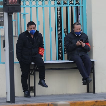 Two security guards wear masks at the entrance to a residential building at the central business area in downtown Beijing. Photo: SCMP