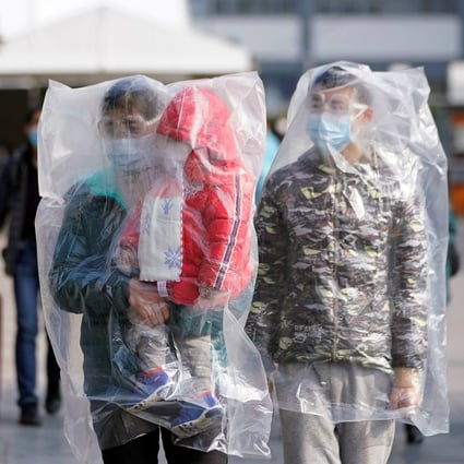 Passengers wear masks and plastic bags at Shanghai railway station as China balances containment with returning to work. Photo: Reuters
