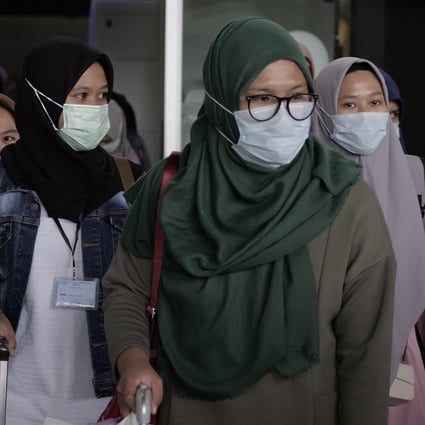 Airline passengers in face masks seen at an airport in Cengkareng on February 1, 2020. Photo: Getty Images/TNS