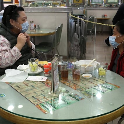 A perspex wall divides two diners who know each other at a cha chaan teng in Tai Kok Tsui in Kowloon. Photo: Nora Tam