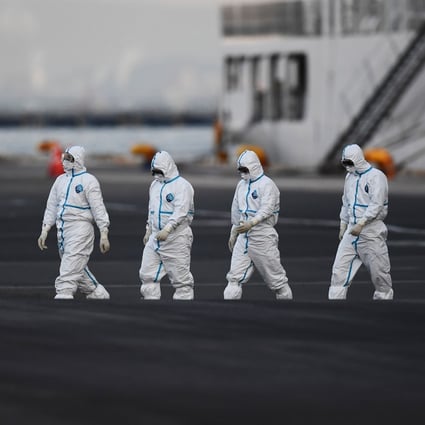 People wearing protective suits walk from the Diamond Princess cruise ship, aboard which around 3,600 people are quarantined due to fears of the new coronavirus, in Yokohama port. Photo: AFP