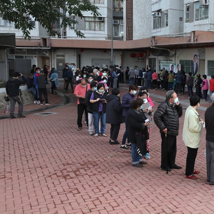 Residents queue for masks sponsored by a chain store, at Hong Mei House in Cheung Hong Estate, Tsing Yi, on February 12. More than 100 residents were evacuated the previous day after coronavirus cases were diagnosed in the block. Photo: Xiaomei Chen