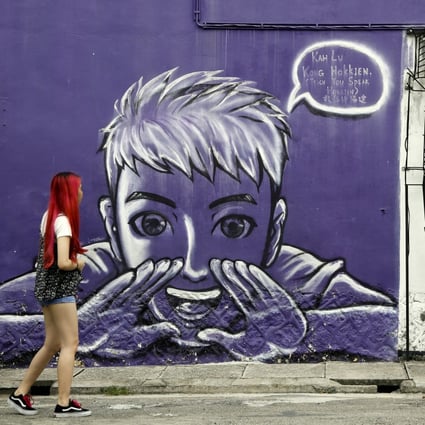 A woman looks at street art on a wall in George Town on the island of Penang, Malaysia, in November 2017. Photo: AP