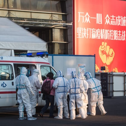 Medical staff admit a coronavirus patient to a temporary hospital set up at Wuhan Sports Centre in Wuhan on Wednesday. Photo: Xinhua