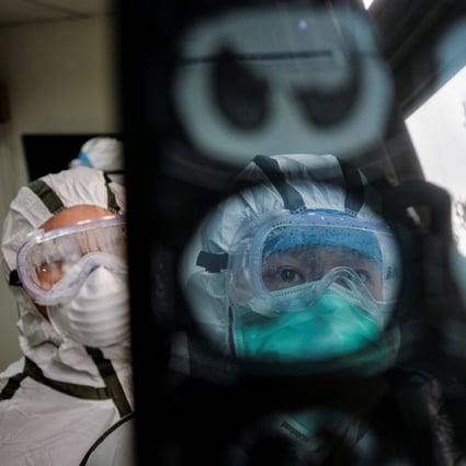 Medical workers in protective suits check a CAT scan image of a patient at a community health service centre in Wuhan, Hubei province. Photo: China Daily via Reuters