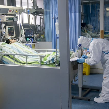 A medical worker attends to a patient suffering from Covid-19 in Zhongnan Hospital, in Wuhan, Hubei province. Companies from across the world are speeding up efforts to find a cure for the pneumonia-like disease caused by the coronavirus. Photo: Xinhua via AP