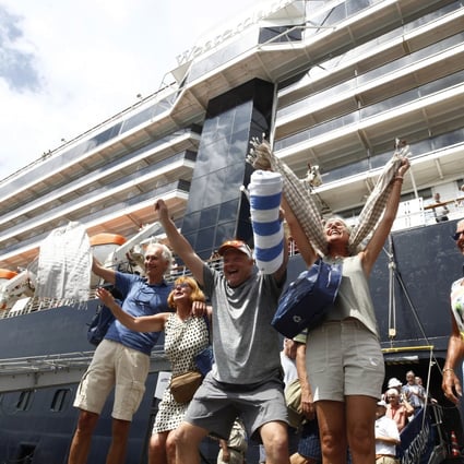 Passengers disembarking from the MS Westerdam at Sihanoukville in Cambodia on Friday, February 14, 2020. Hundreds of cruise ship passengers long stranded at sea by virus fears cheered as they finally disembarked Friday and were welcomed to Cambodia. Photo: AP