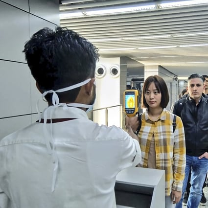 Passengers have their temperatures taken at Netaji Subhash Chandra Bose International Airport in Kolkata. Photo: AFP