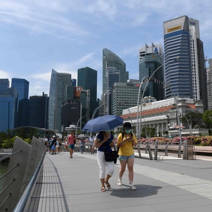 People wearing protective face masks amid fears about the spread of Covid-19, walk over the Jubilee Bridge in Singapore. Photo: AFP