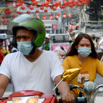 Motorists wearing face masks making their way along a street in Manila’s Chinatown district of Binondo. Photo: AFP