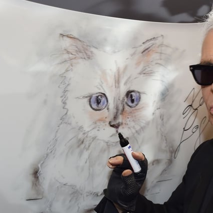 Karl Lagerfeld poses next to a sketch of his cat, Choupette, in February 2015. Photo: AFP