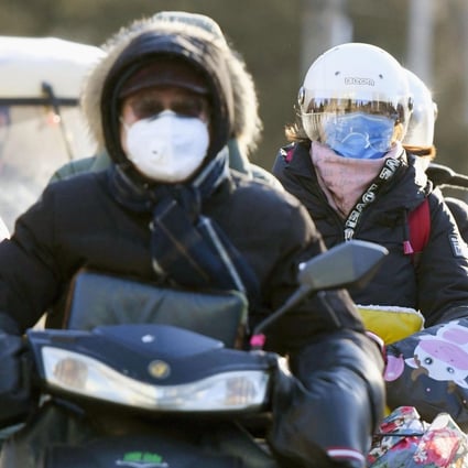 Motorists wearing masks in Beijing. Photo: Kyodo