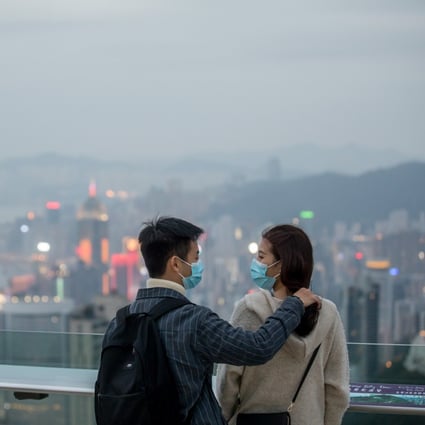 People wearing protective masks stand on a viewing terrace at Victoria Peak in Hong Kong on February 3. Hong Kong needs strong community bonds, including those between the government and people, to survive the coronavirus and other crises. Photo: Bloomberg