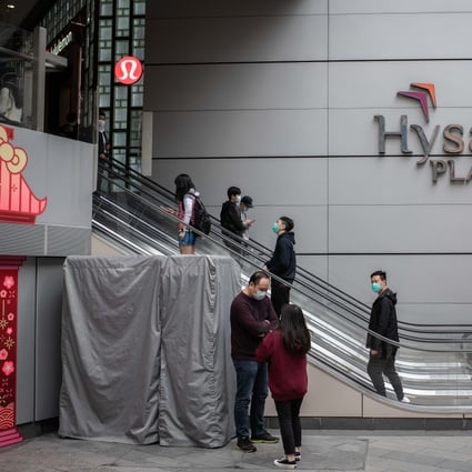 People wearing protective masks ride on escalators at the Hysan Place shopping mall in Causeway Bay shopping district in Hong Kong. Photo: Bloomberg