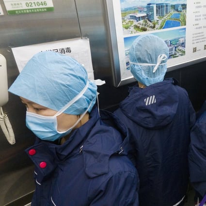 Workers in a lift at Tongji Hospital in Wuhan, China, face in different directions to prevent cross-infection. Photo: Xinhua