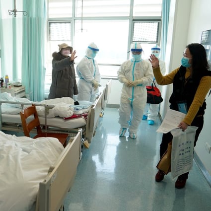 A woman in Wuhan says goodbye to other patients after recovering and being discharged from hospital. Photo: Xinhua