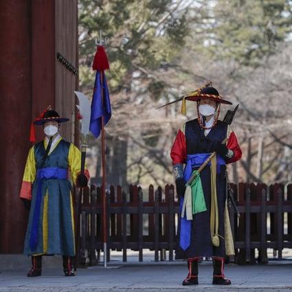 Workers in traditional outfits, along with surgical masks, at a palace in Seoul, South Korea. A coronavirus outbreak in the country has worsened in recent days. Photo: AP