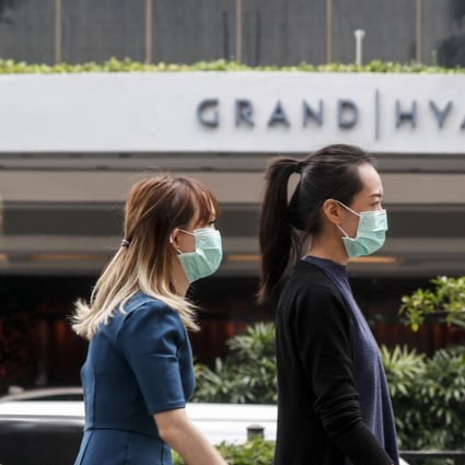 Two women in protective masks walk past a hotel in Singapore on February 7, 2020. Photo: EPA