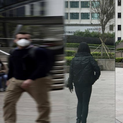 People in protective masks in Central, the main business district of Hong Kong, where rental rates for commercial property have plummeted. Photo: AP